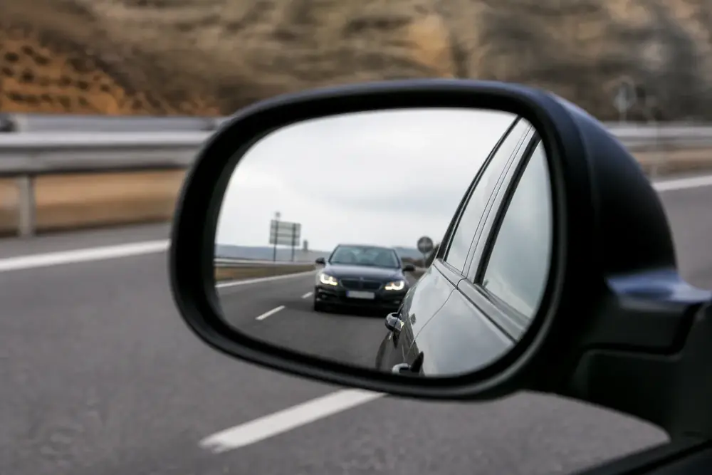 Retrovisor exterior con un vehículo aproximándose por detrás