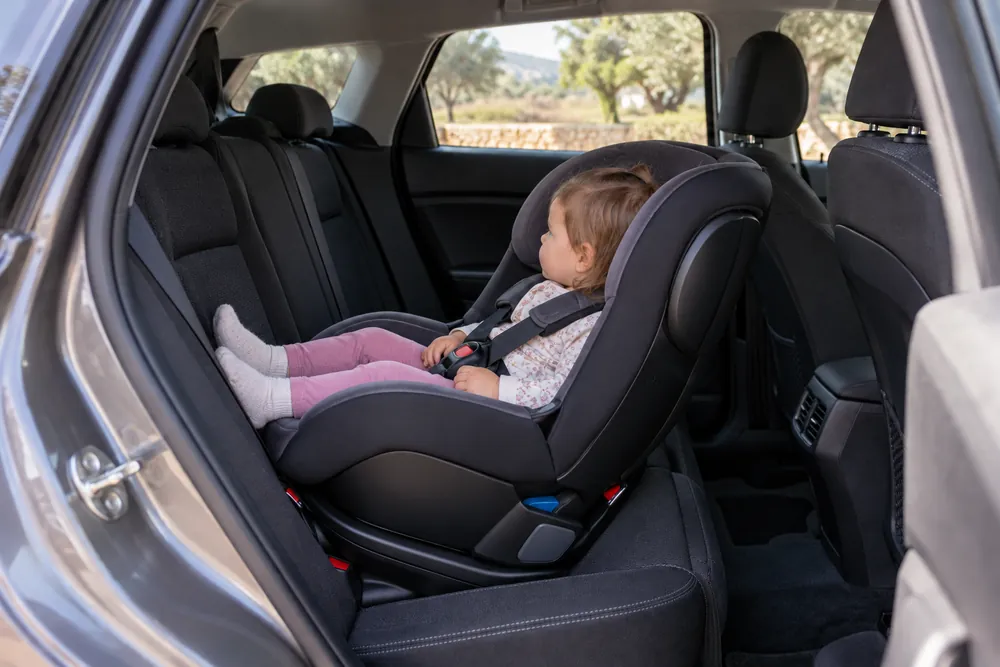 Silla infantil instalada a contramarcha en el asiento trasero con un niño pequeño.