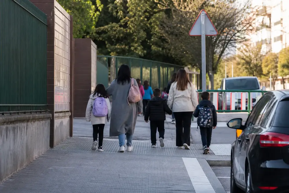 Salida de un colegio con niños cruzando acompañados